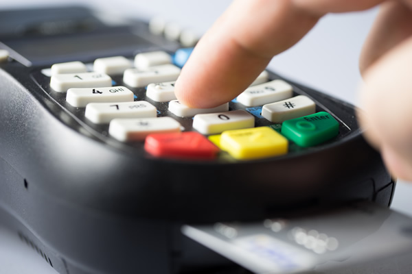 Man typing PIN on card reader